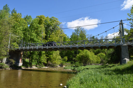 View from below on a river looking up at a vehicle going over a bridge in Rouge Park