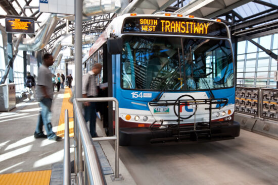 Winnipeg transit bus picking up passengers at a station
